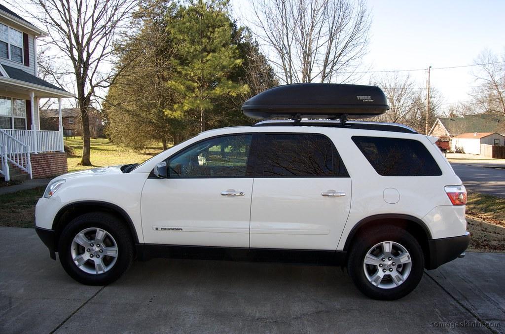 A white SUV with the cargo roof box